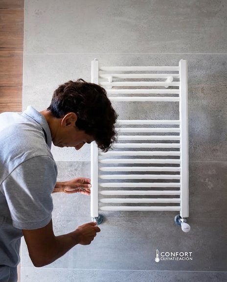 Técnico de Confort Climatización instalando un radiador toallero en un baño de Salta